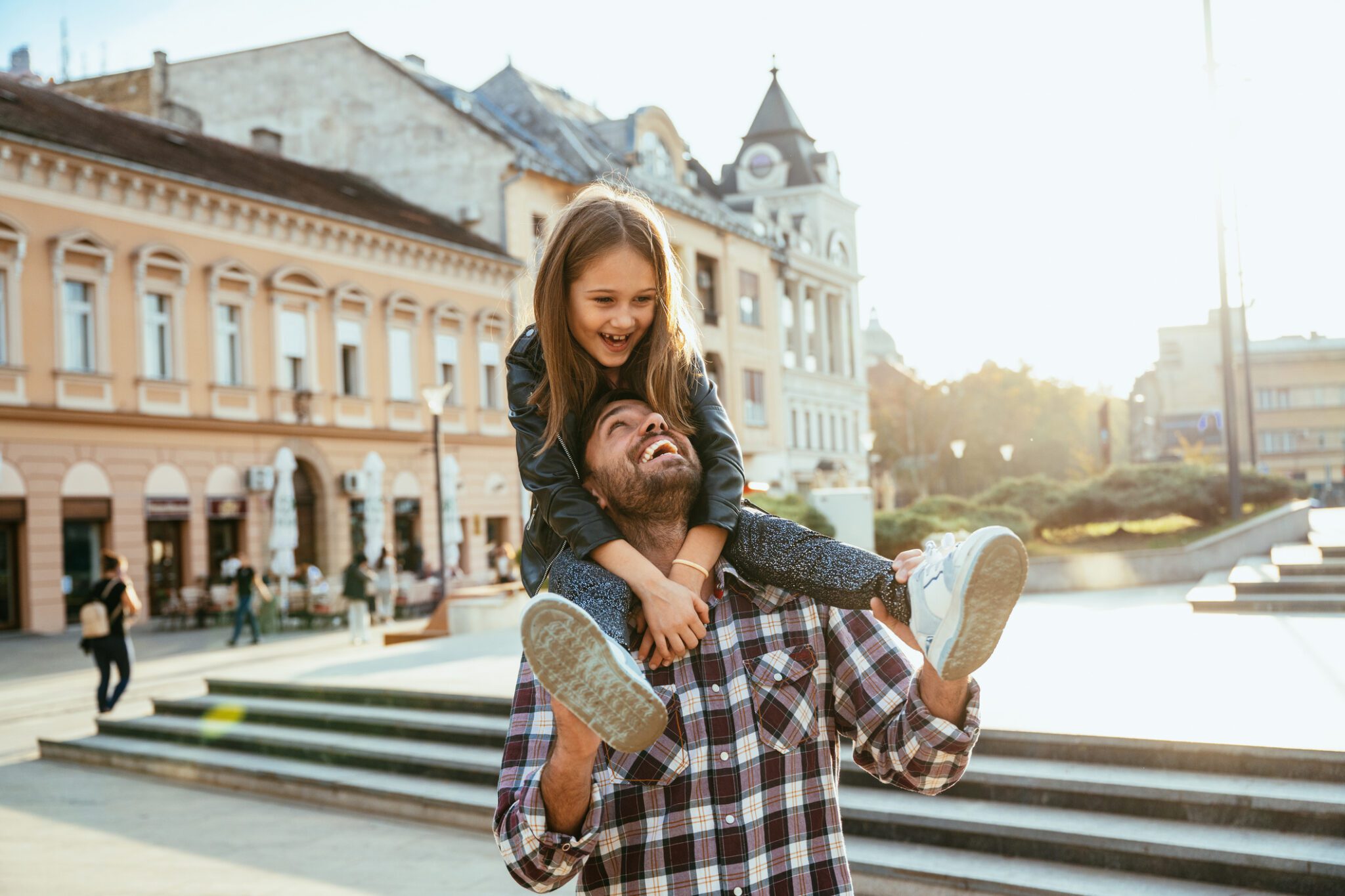 Father and daughter laughing outdoors